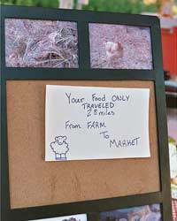 Sign on notice board at farmer's market says 'Your food only traveled 28 miles from farm to market.'