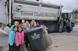 Photo of kids around a big recycling container.