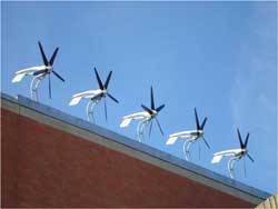 Close-up photo of architectural wind turbines on building roof.