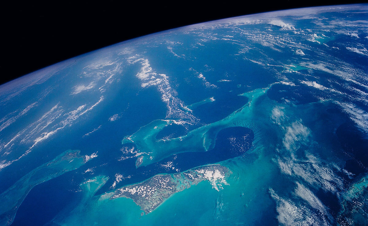 A view of the Bahamas from high above Earth's surface, with the Earth's curved horizon in the distance.