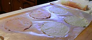 Several paper 'patties' are drying on a piece of waxed paper.