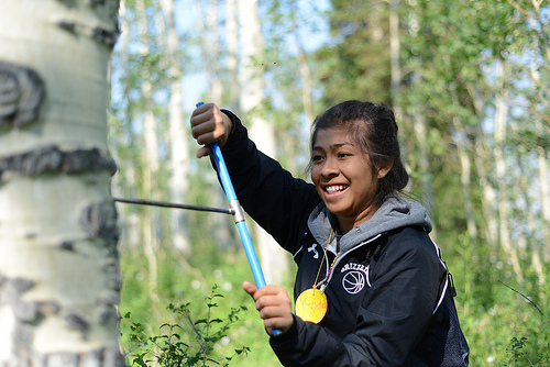 A student learns how to take a tree core sample with an increment borer in the Manti-LaSal National Forest in Utah.